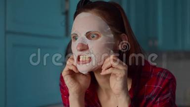 滑稽的30多岁的女人，脸上戴着白色化妆面具，在家里做<strong>鬼脸</strong>。 戴着蓝色面具做<strong>鬼脸</strong>的女人